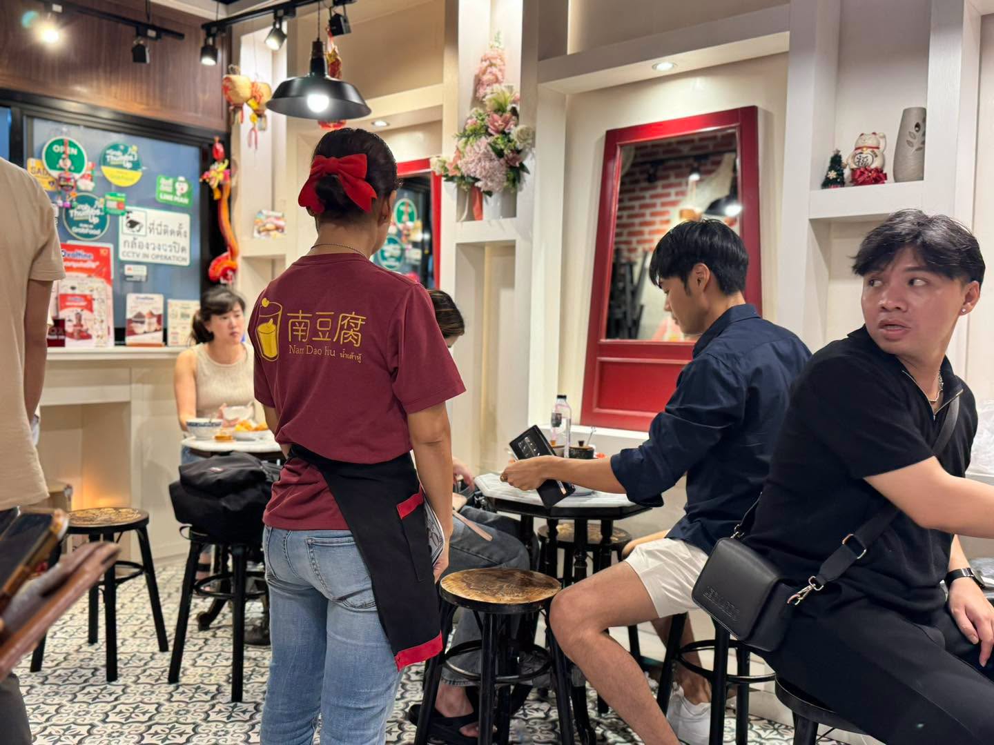มุมร้านตกแต่งด้วยกระจกกรอบแดงและของมงคลจีน